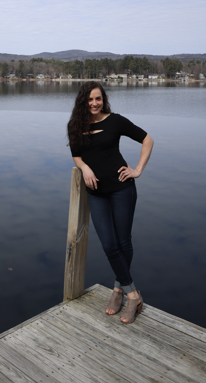 middle age female standing on dock at the lake with hand on her hip