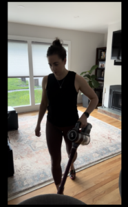 girl in black tank top vacuuming